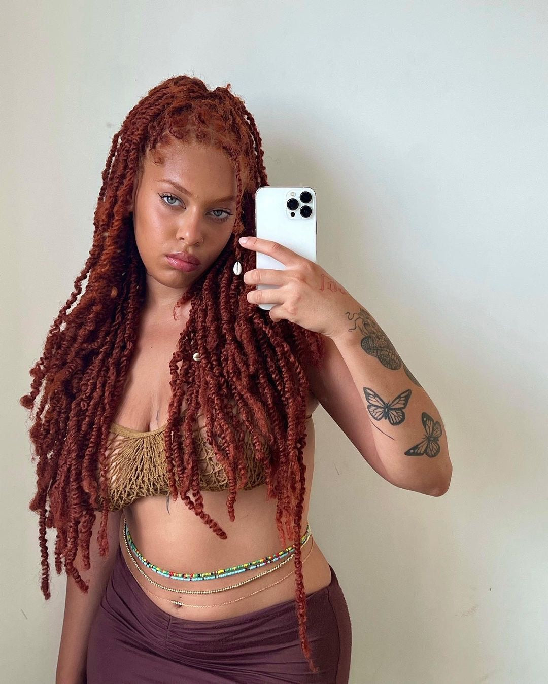 Mixed girl waring waist beads with ginger dreadlocks